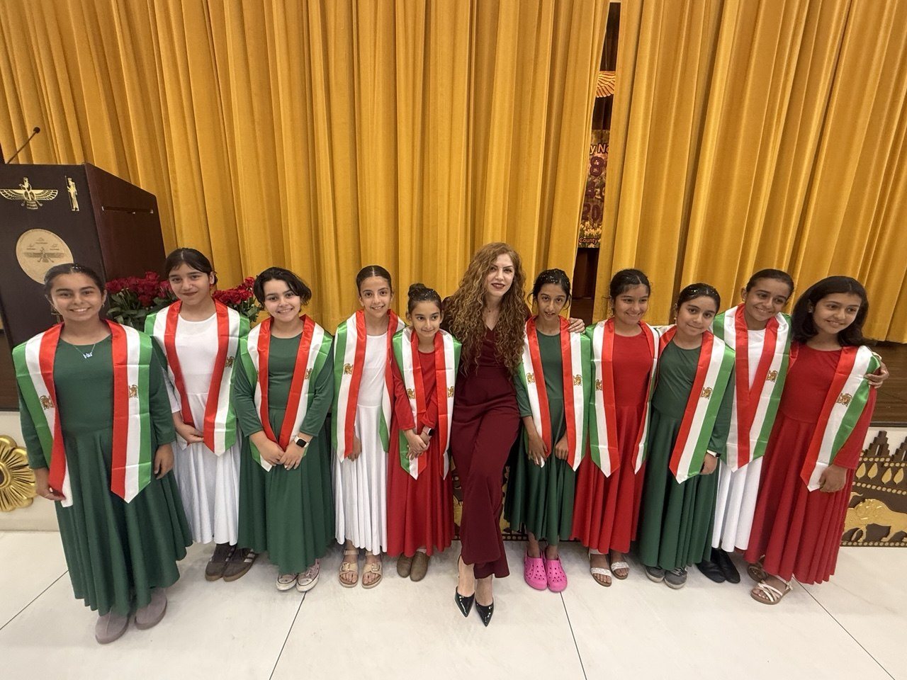 Elham standing with a line of students after a performance